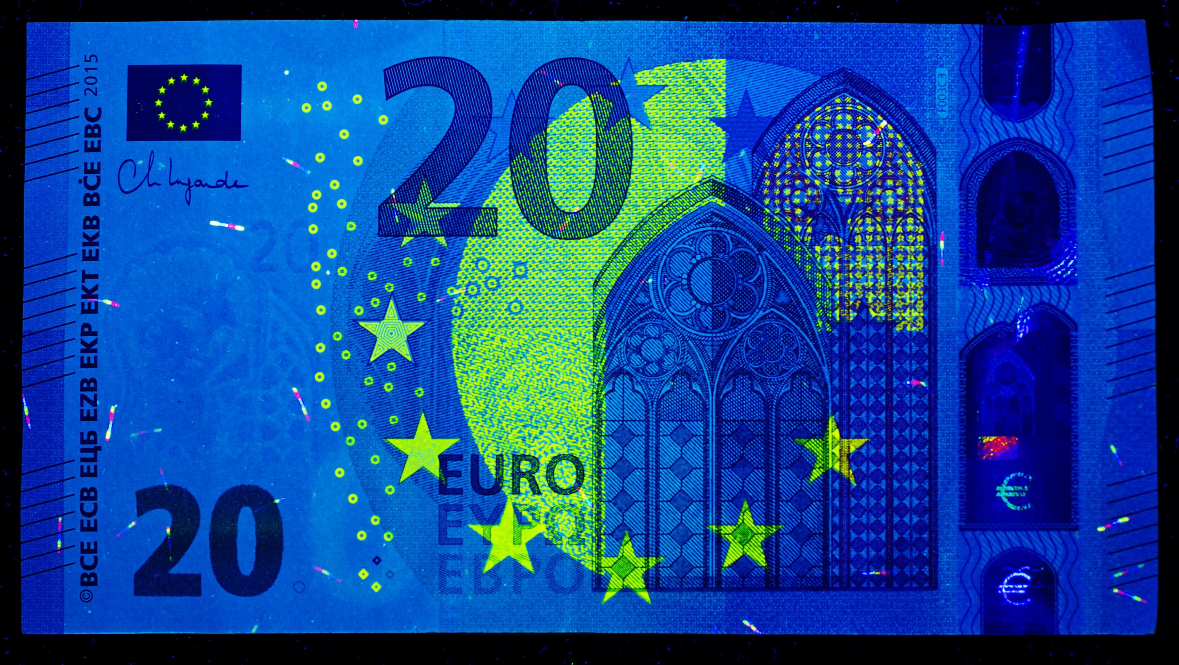 20-Euro-Schein unter UV-Licht, Sicherheitsmerkmale leuchten sichtbar auf.